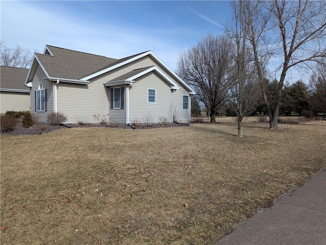 view of property exterior featuring a yard and roof with shingles