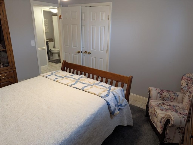 bedroom with a closet, baseboards, and wood finished floors