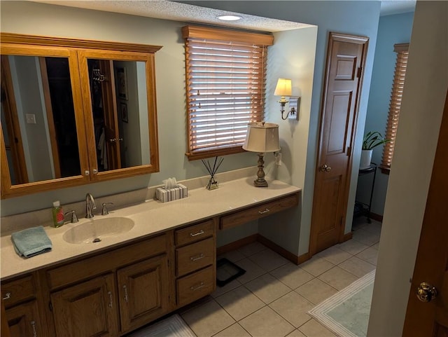 bathroom with vanity, tile patterned floors, and baseboards