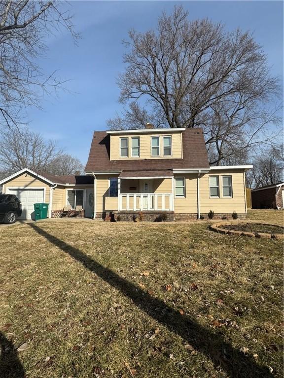 view of front of house featuring a garage, covered porch, and a front yard