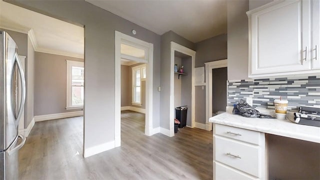 437 Powers Ln, Decatur, IL 62522 - kitchen featuring freestanding refrigerator, backsplash, light wood-style floors, white cabinetry, and crown molding