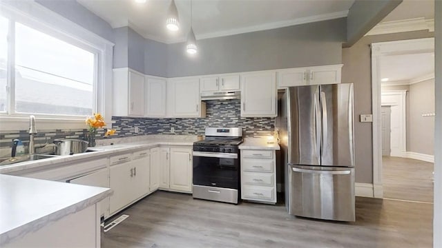 437 Powers Ln, Decatur, IL 62522 - kitchen featuring stainless steel appliances, crown molding, under cabinet range hood, white cabinets, and light countertops