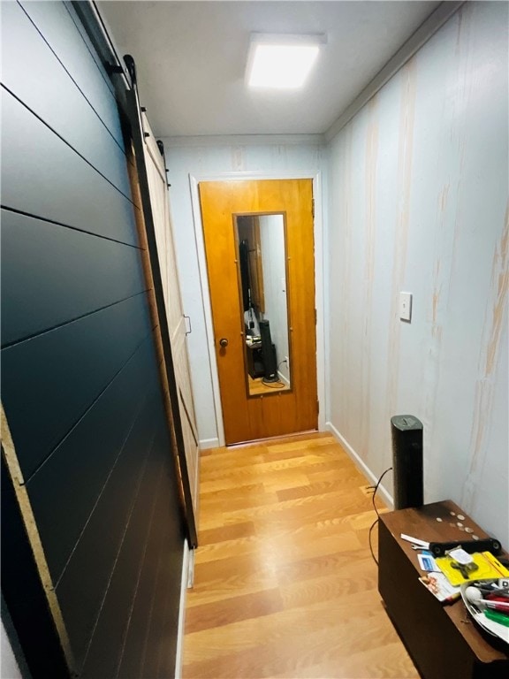 hallway featuring a barn door and light wood-type flooring