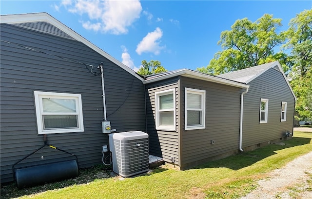 view of property exterior with a yard and central AC