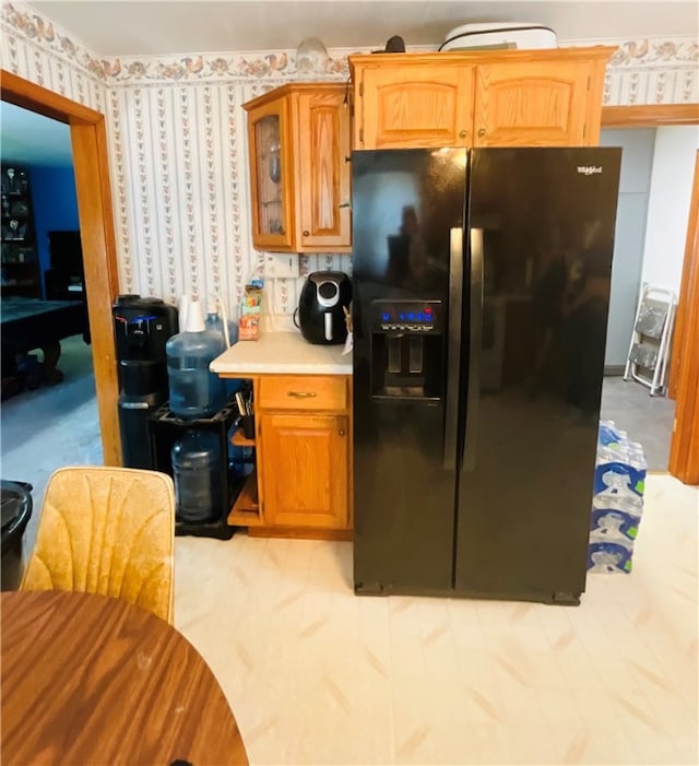 kitchen featuring light carpet and black fridge