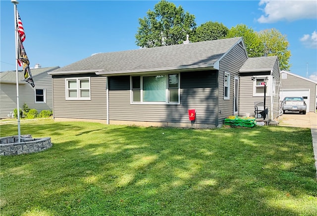 exterior space featuring a lawn, a garage, and an outdoor structure