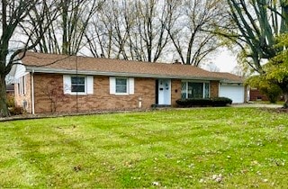 ranch-style house with a garage and a front lawn