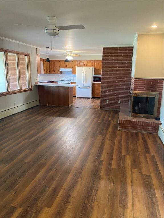 unfurnished living room with a brick fireplace, dark wood-type flooring, ornamental molding, and ceiling fan