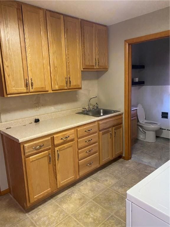 kitchen featuring stove, sink, and a baseboard heating unit