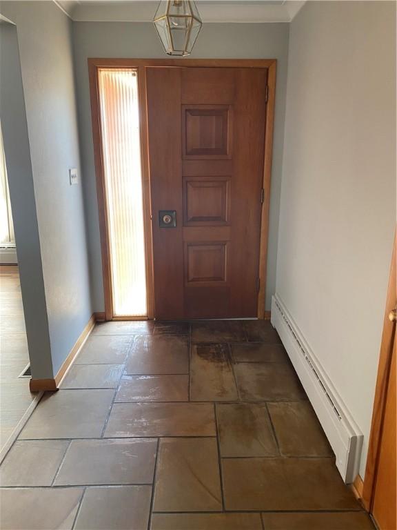 entryway featuring crown molding and baseboard heating