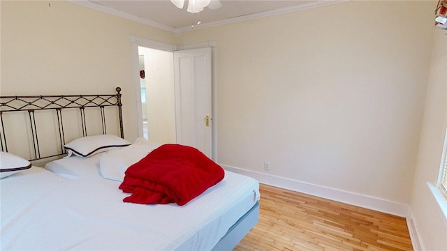 bedroom with a ceiling fan, baseboards, ornamental molding, and wood finished floors