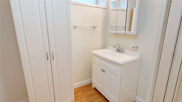 bathroom with baseboards, wood finished floors, and vanity