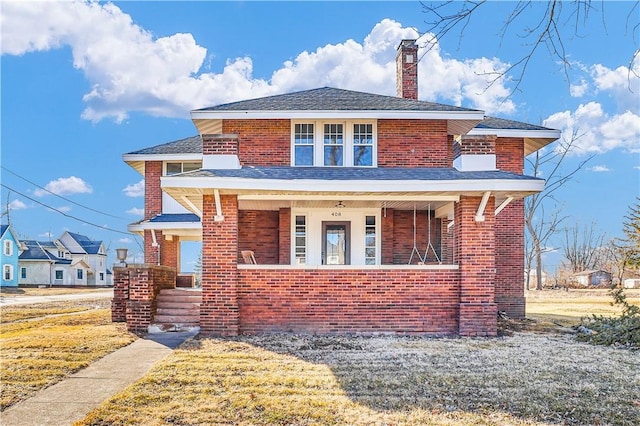 view of front of property featuring brick siding, a chimney, and a porch