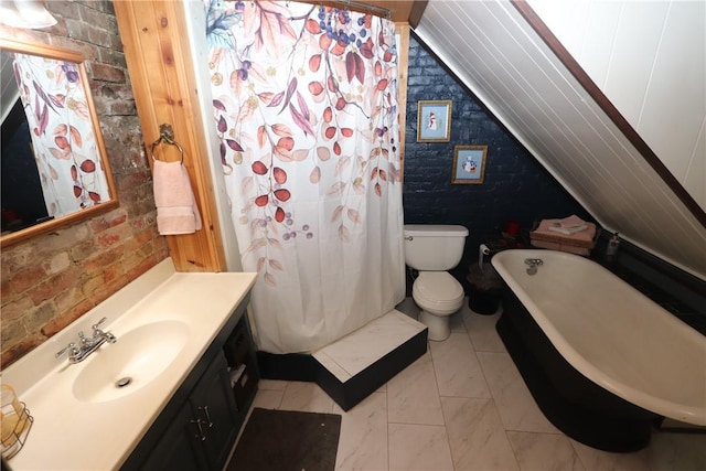 bathroom with toilet, vaulted ceiling, vanity, a bathing tub, and brick wall