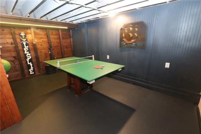 playroom featuring concrete floors and wood walls