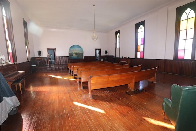 recreation room featuring hardwood / wood-style floors, a notable chandelier, and wood walls