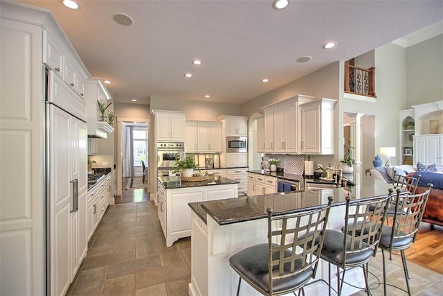 4140 S Lake Ct, Decatur, IL 62521 - kitchen with built in appliances, recessed lighting, a center island, a sink, and decorative columns