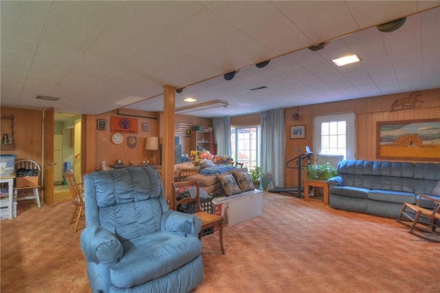 living area featuring carpet and wood walls