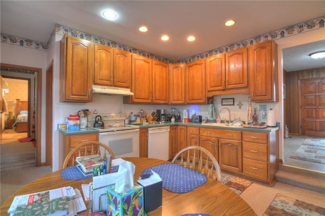 kitchen with white appliances, under cabinet range hood, a sink, and recessed lighting