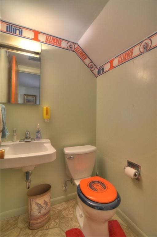 half bathroom featuring baseboards and toilet