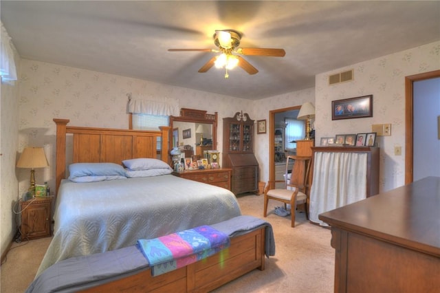 bedroom with light colored carpet, visible vents, ceiling fan, and wallpapered walls