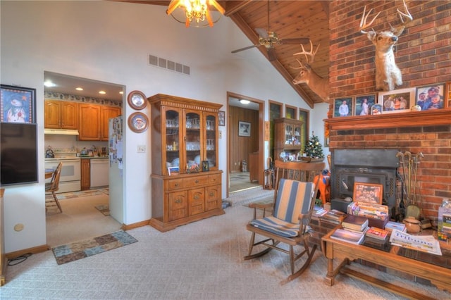 living area with high vaulted ceiling, light colored carpet, visible vents, baseboards, and a brick fireplace