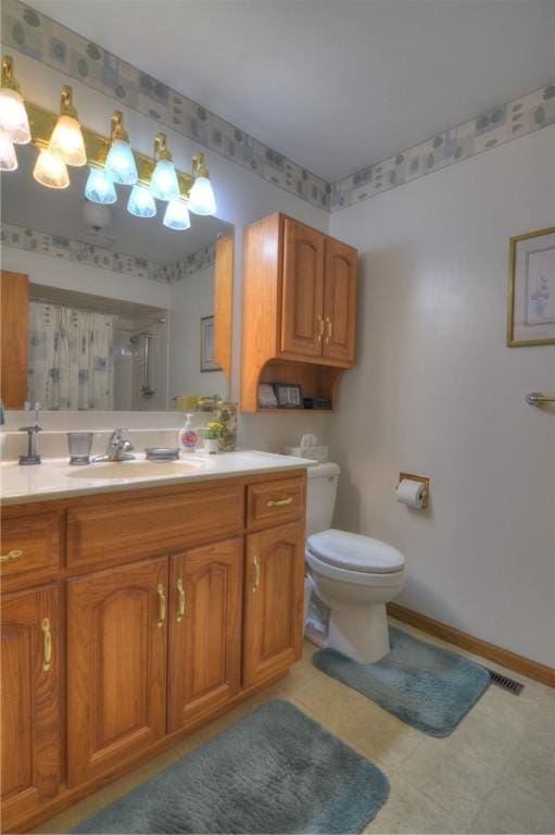 bathroom featuring visible vents, baseboards, toilet, walk in shower, and vanity