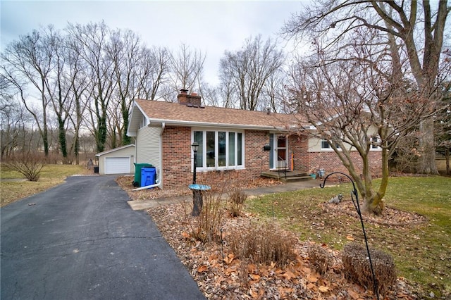 view of front facade featuring brick siding, roof with shingles, a chimney, a garage, and a front lawn