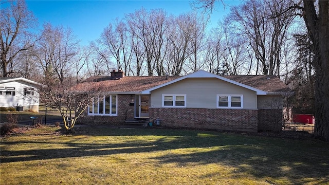 view of front of property featuring brick siding, a chimney, and a front lawn