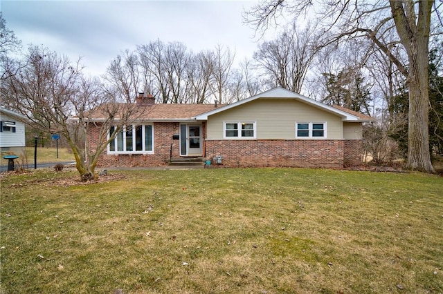 ranch-style house with brick siding, a chimney, and a front lawn