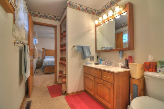 ensuite bathroom with baseboards, visible vents, connected bathroom, toilet, and vanity