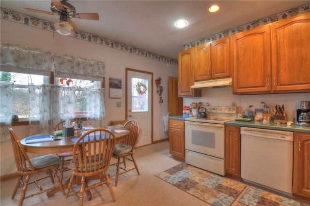 kitchen featuring brown cabinetry, recessed lighting, white appliances, and under cabinet range hood