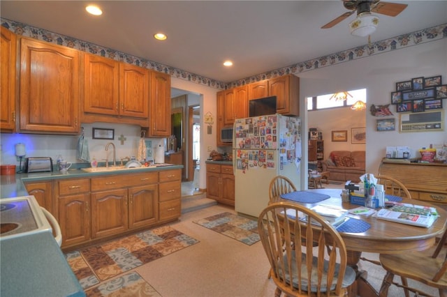 kitchen with a ceiling fan, stainless steel microwave, brown cabinets, freestanding refrigerator, and recessed lighting