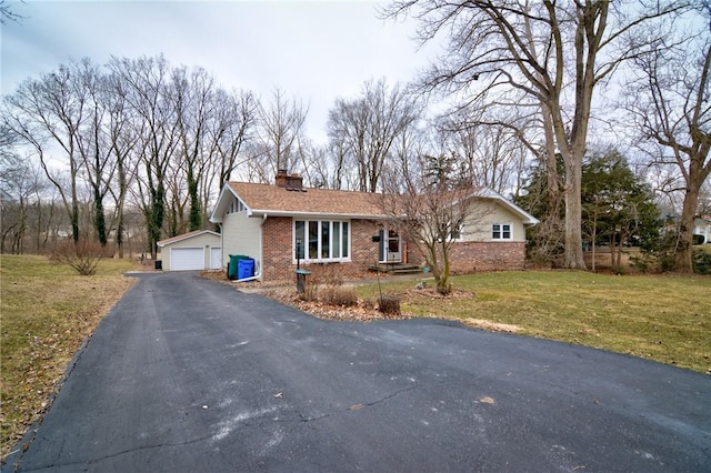 view of front of home featuring a chimney, a detached garage, an outdoor structure, a front lawn, and brick siding