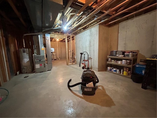 basement featuring heating unit and water heater