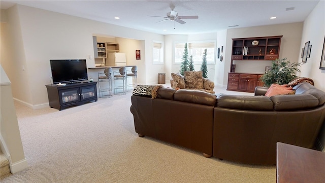 carpeted living room with ceiling fan