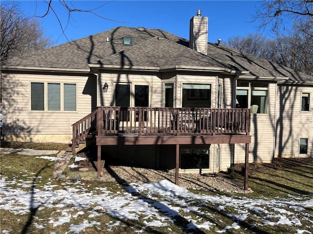 snow covered back of property featuring a deck