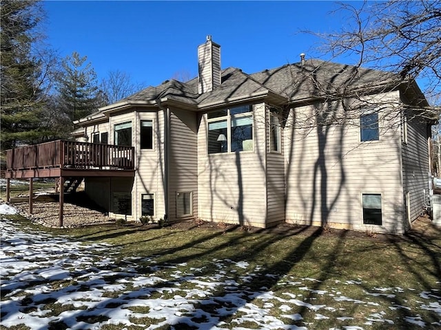 view of snowy exterior with a lawn and a deck