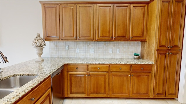 kitchen with sink, light tile patterned floors, dishwasher, light stone countertops, and backsplash