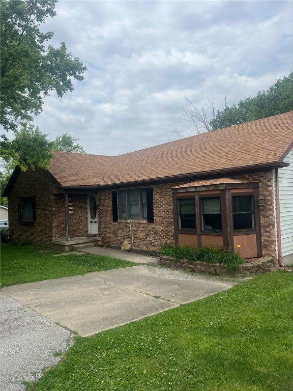 208 Roosevelt St, Paris, IL 61944 - ranch-style house with a shingled roof, a front lawn, and brick siding