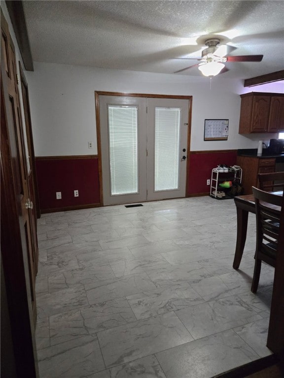 208 Roosevelt St, Paris, IL 61944 - dining space with light marble finish floors, wainscoting, a textured ceiling, and ceiling fan