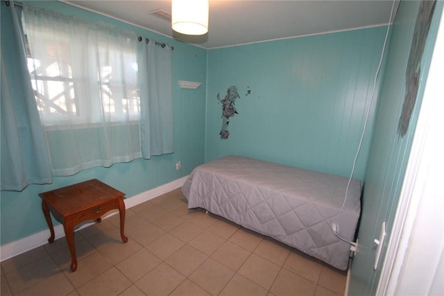 bedroom with baseboards and light tile patterned floors