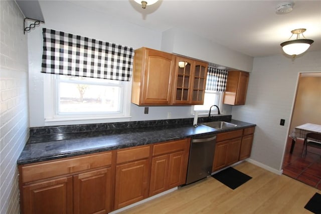 kitchen featuring a sink, plenty of natural light, brown cabinetry, and dishwasher