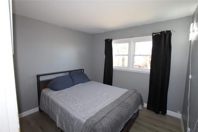 bedroom with baseboards and wood finished floors