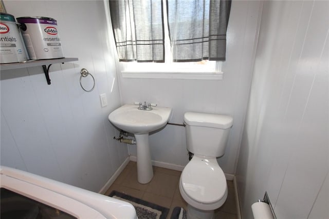 bathroom with toilet, tile patterned flooring, and baseboards