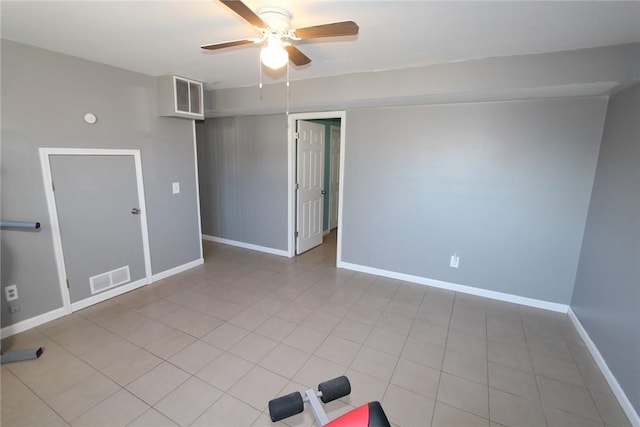 spare room with a ceiling fan, visible vents, baseboards, and light tile patterned floors