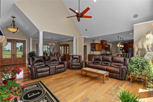 11107 E Cambridge Ln, Effingham, IL 62401 - living room with a chandelier, ceiling fan, light wood-type flooring, decorative columns, and high vaulted ceiling