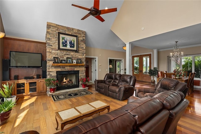 11107 E Cambridge Ln, Effingham, IL 62401 - living area with a towering ceiling, a chandelier, wood finished floors, ceiling fan, and a stone fireplace