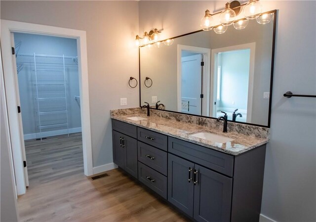 3812 Sonny Ln, Danville, IL 61832 - bathroom with double vanity, wood finished floors, a walk in closet, and baseboards