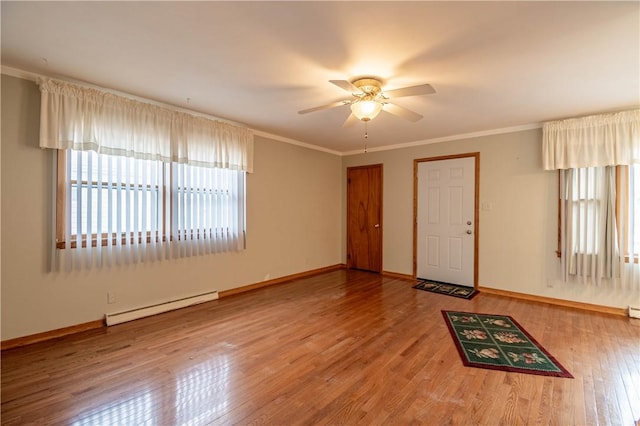 interior space with crown molding, wood-type flooring, a baseboard heating unit, ceiling fan, and baseboards